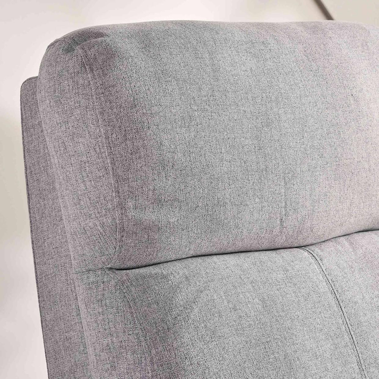 Close-up of light gray upholstered sofa backrest with soft fabric texture
