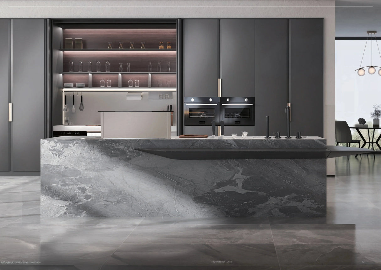 Modern kitchen with sleek gray cabinets, built-in double oven, and large gray marble island