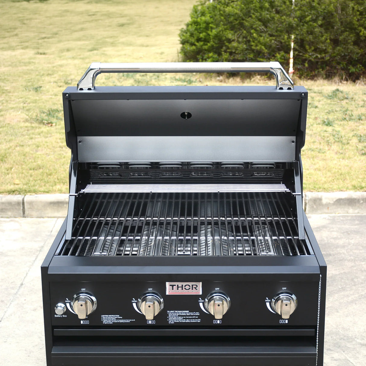 Outdoor gas grill with four burners, stainless steel knobs, and open hood on patio