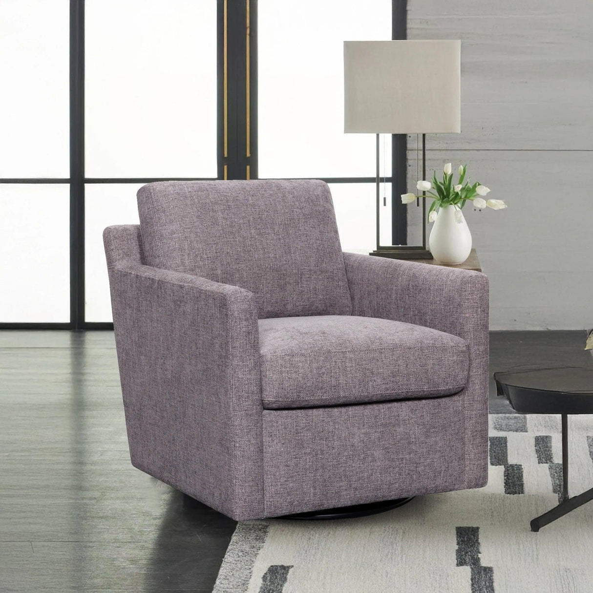 Modern pewter swivel accent chair in living room with lamp and white tulip vase