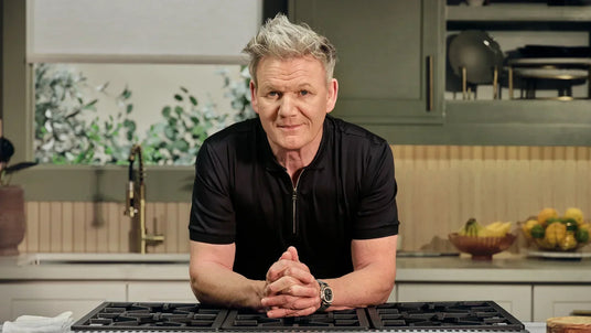 Chef in modern kitchen with Thor Kitchen stove, leaning on counter, kitchenware visible