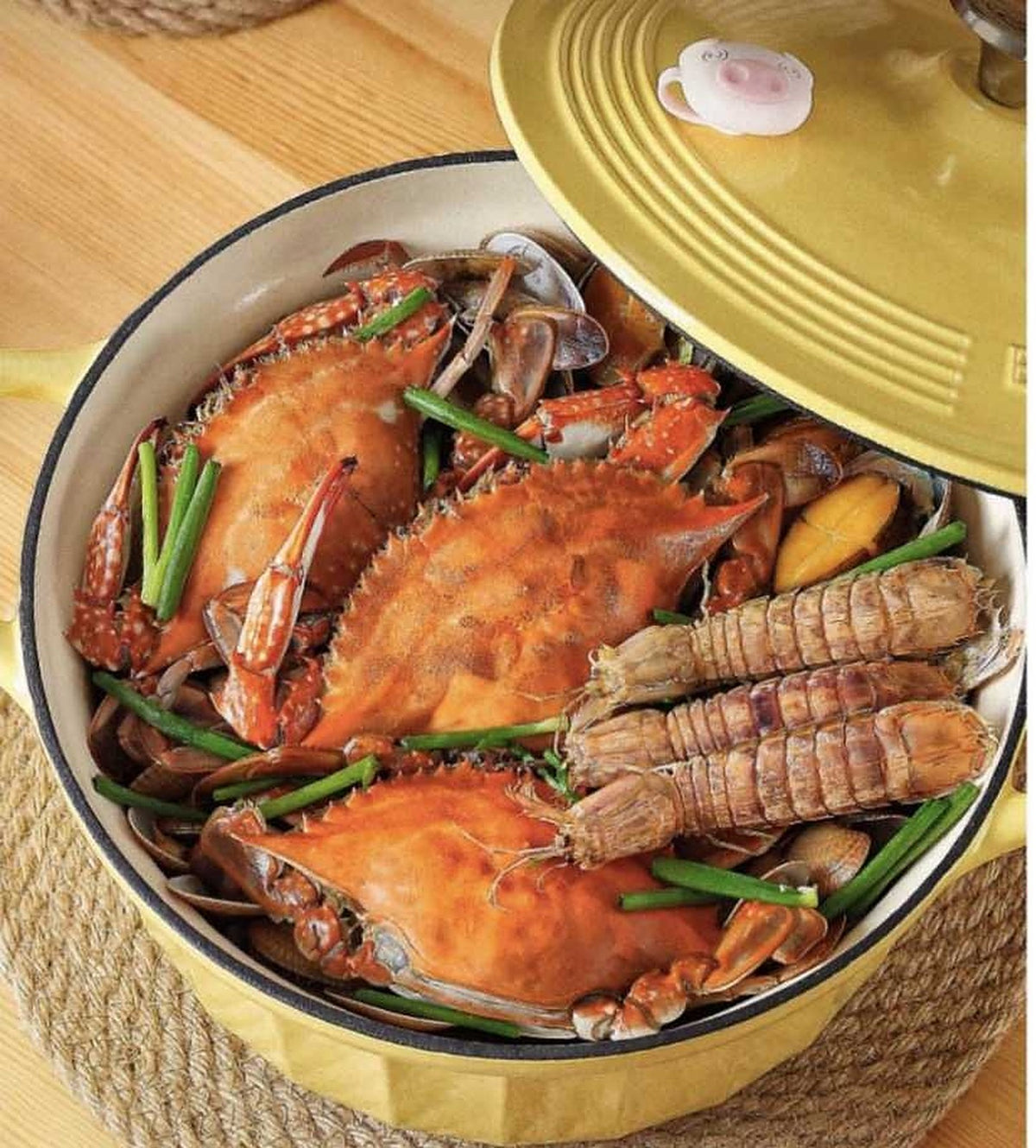 BUYDEEM CP551 Enamel Cast Iron Casserole 25cm – braised seafood in the yellow pot, lid with pig stopper beside