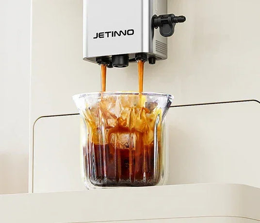 Jetinno coffee machine dispensing iced coffee into glass cup, modern kitchen appliance UAE