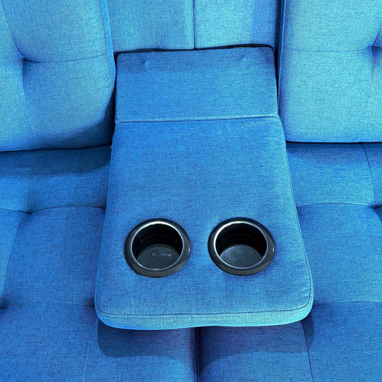 Blue upholstered sofa with two built-in cup holders in center armrest