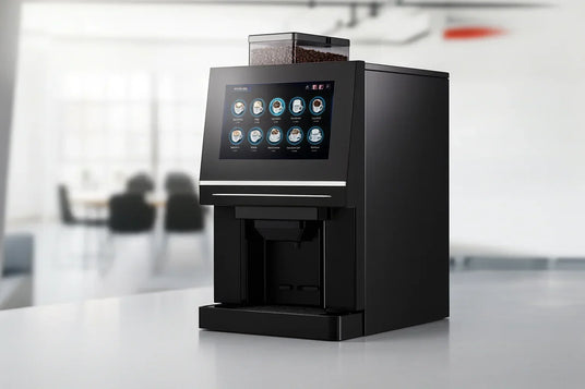 Modern black coffee maker with touchscreen controls on a kitchen counter in a bright room