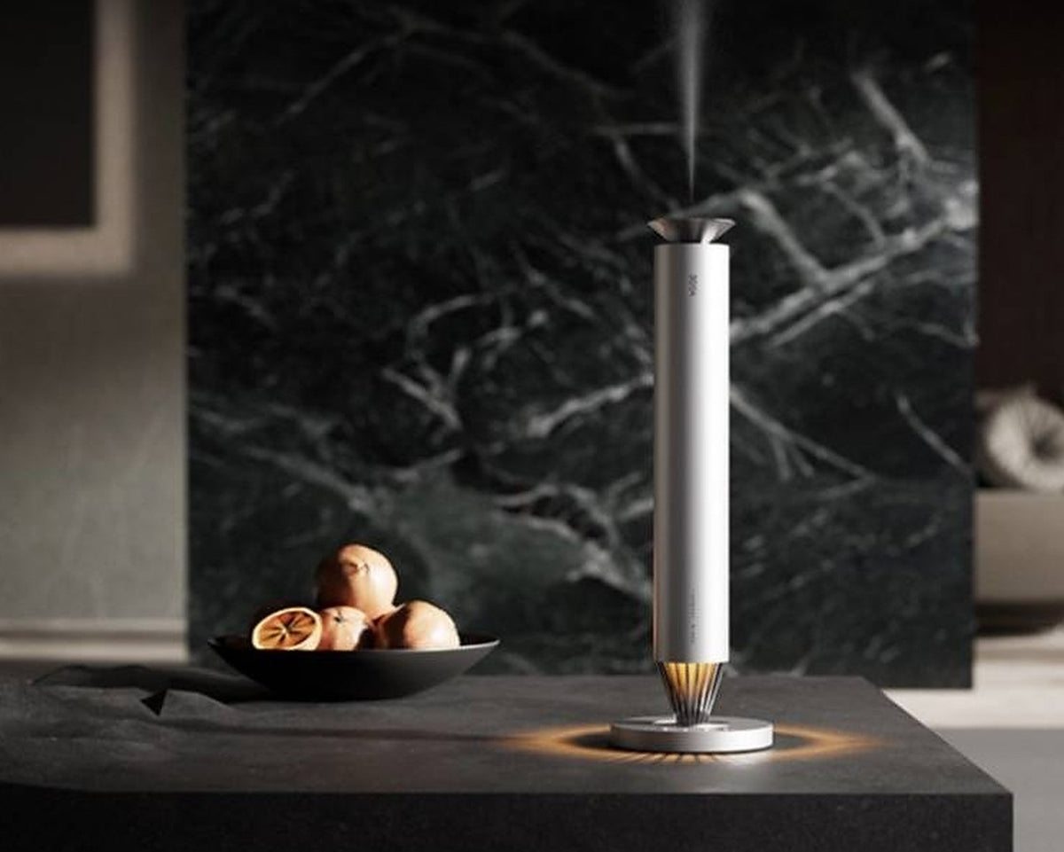 3004 V900S Desktop Aroma Diffuser – Frosted Silver – V900S misting on black stone table against marble wall