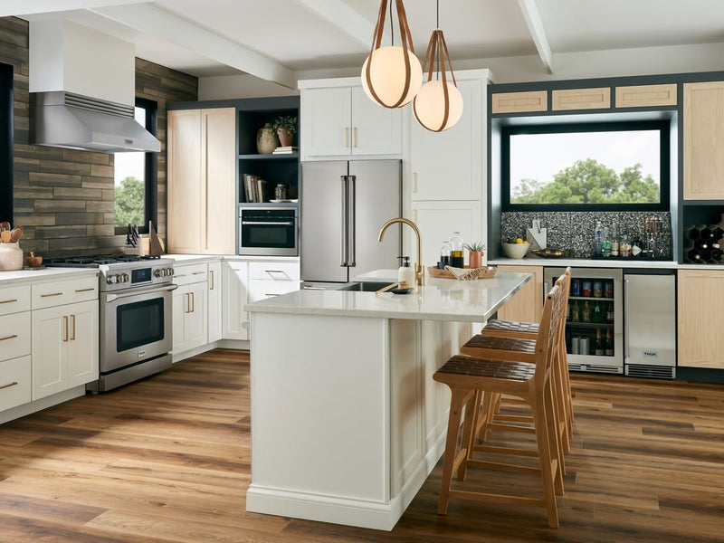 Modern kitchen with stainless steel THOR Kitchen appliances, island, and wood accents.