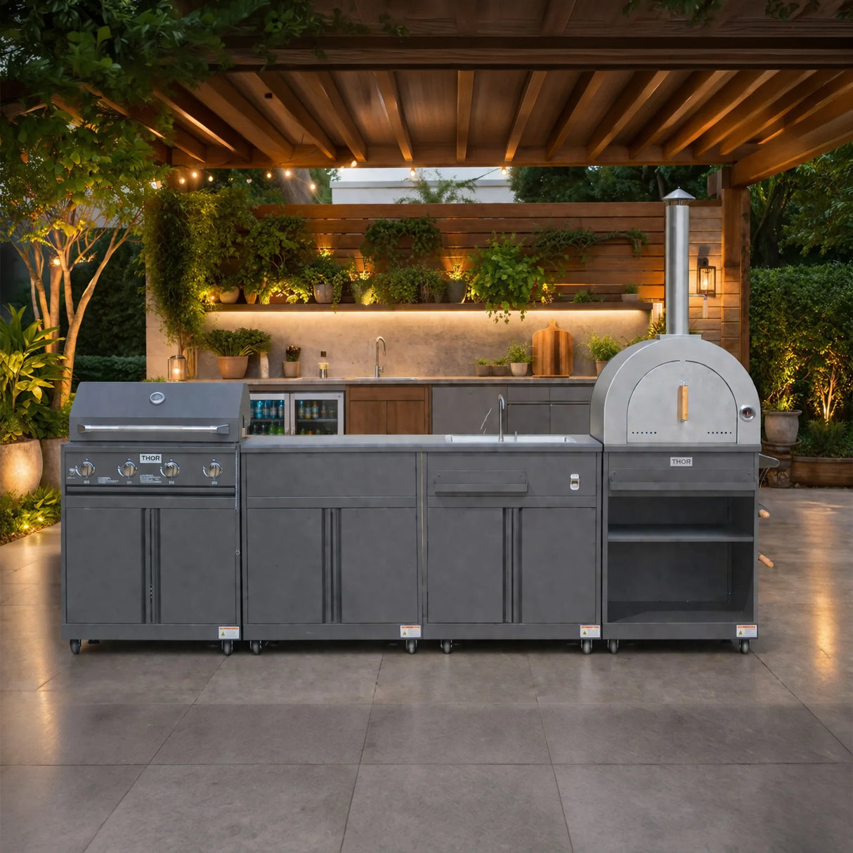 Modern outdoor kitchen with stainless steel grill, pizza oven, sink and garden lighting