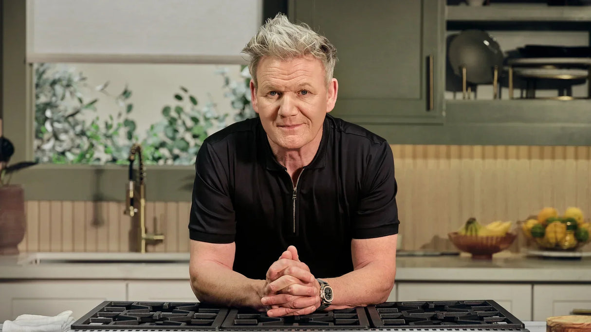 Chef in modern kitchen with Thor Kitchen stove, leaning on counter, kitchenware visible