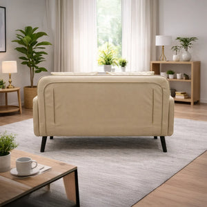 Beige two-seater sofa in modern living room with plants, coffee table, and natural light