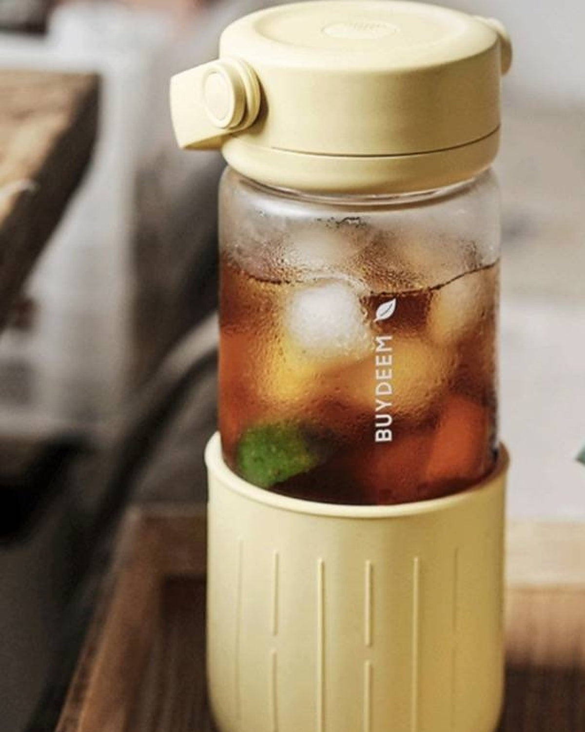 BUYDEEM DG45 Glass Tea Tumbler with Titanium Infuser 470ml – yellow tumbler with iced tea and lime on a wooden tray