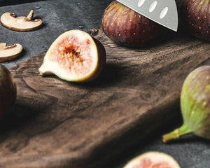 SNF MS2 Avant Classic 7-Inch Santoku Knife – Olive Wood – figs and mushrooms on a dark wooden board, santoku blade tip at top