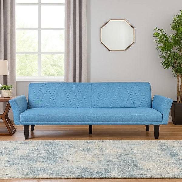 Modern blue sofa bed with diamond stitching in a bright living room with wood floor